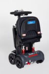 Monarch Genie black automatic folding mobility scooter side view showing red suspension springs and compact folded design