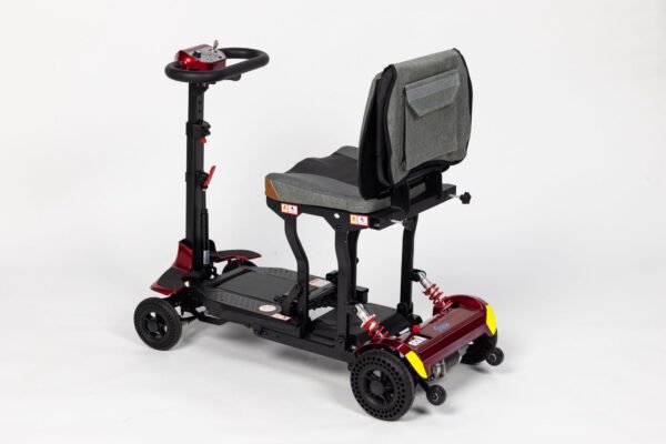 Monarch Genie lightweight folding travel scooter three-quarter view showing red and black design with adjustable seat