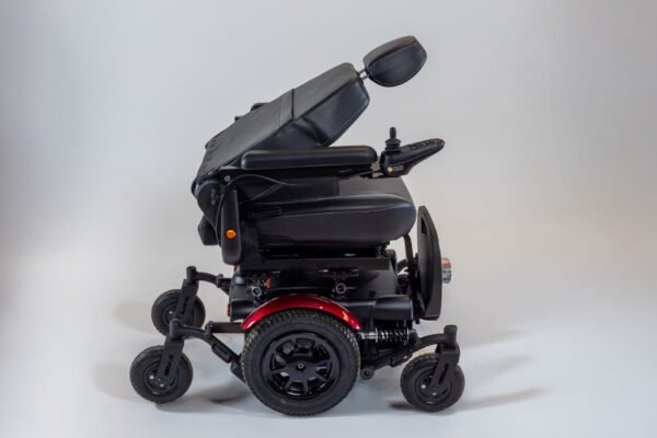 Monarch Super Powerchair side profile view showing black leather seat, red accent trim, and all-terrain wheels