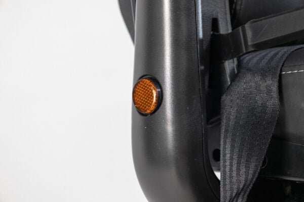 Monarch Super Powerchair detail view showing orange safety reflector on black frame with seat straps