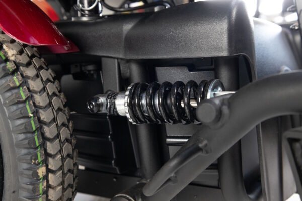 Monarch Super Powerchair rear suspension detail view showing black coil spring shock absorber system