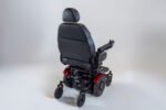 Monarch Super Powerchair shown from rear three-quarter angle with black leather seat and red accents